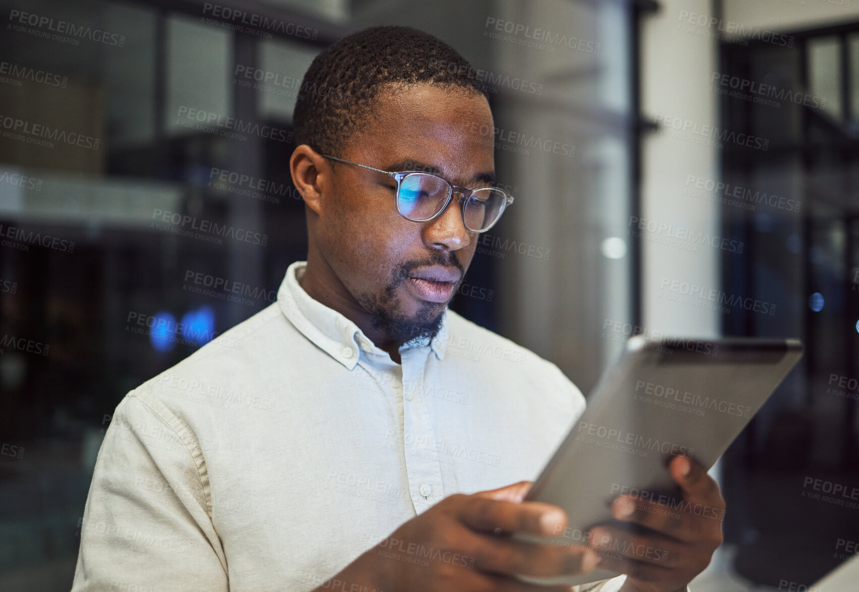 Buy stock photo Tablet research, night planning and businessman working on email on the internet while in a dark office at work. Corporate African employee reading communication online on tech while doing overtime