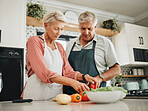 Elderly, couple and kitchen for cooking with vegetables on countertop for nutrition. Man, woman and in retirement learning to cook for healthy diet in home together, love and food in family home