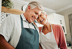 Senior couple, love and cooking while wearing an apron, laughing and happy bonding together in their home kitchen and enjoying healthy relationship. Old man and woman enjoying retirement with a smile