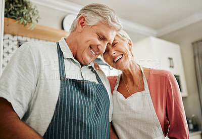 Buy stock photo Senior couple, love and cooking while wearing an apron, laughing and happy bonding together in their home kitchen and enjoying healthy relationship. Old man and woman enjoying retirement with a smile