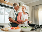 Senior couple, cooking and home bonding for fun, romance and happiness with husband hugging happy wife with love, care and offering help in the kitchen. Food, marriage and joy with old man and woman