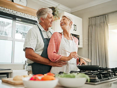 Buy stock photo Senior couple, cooking and home bonding for fun, romance and happiness with husband hugging happy wife with love, care and offering help in the kitchen. Food, marriage and joy with old man and woman