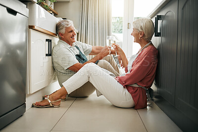 Buy stock photo Champagne celebration, toast and senior couple having a drink to celebrate retirement on the floor of kitchen in home. Elderly man and woman happy on anniversary of marriage with cheers and alcohol