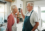 Senior couple, taste and food in kitchen cooking healthy, nutrition and romantic dinner together at home. Happy nutritionist and retired elderly man and woman in retirement tasting lunch or brunch