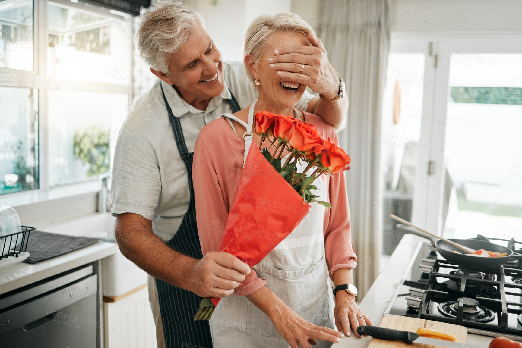 Buy stock photo Senior couple, covering eyes and flowers surprise as man give wife bouquet of roses on an anniversary, birthday or valentines day in kitchen. Happy old man and woman being romantic in Australia house