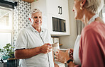 Senior man, drinking coffee and conversation with woman in kitchen at home in New Zealand. Happy, elderly and smile couple enjoy morning tea, chat and relax together in apartment for retirement break