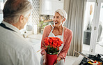 Flowers, love and cooking with a senior couple in a kitchen forsurprise breakfast in celebration of an anniversary, birthday or valentines day. Food, romance and morning with an elderly man and woman