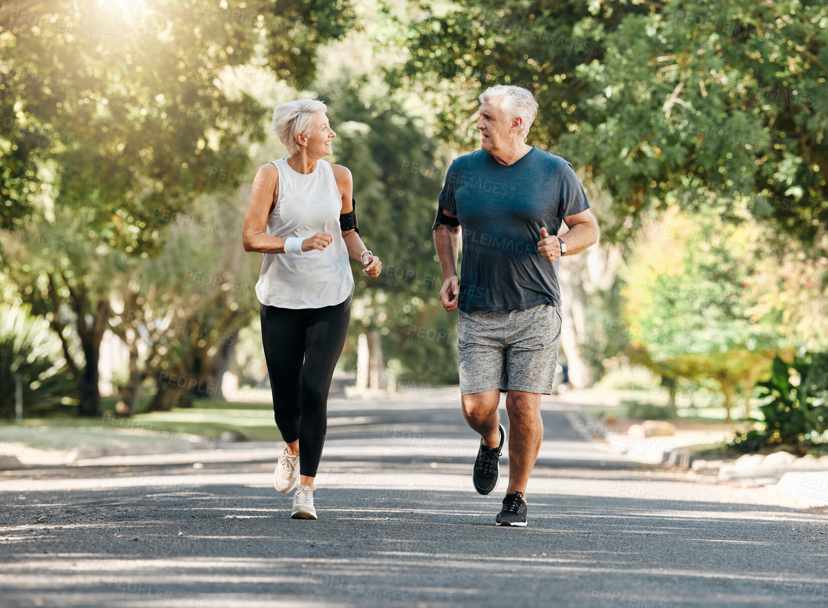 Buy stock photo Health, senior couple and running while talk and exercise for fitness, wellness and healthy together in nature. Retirement, man and woman enjoy workout, chatting and jog outside in park on sunny day