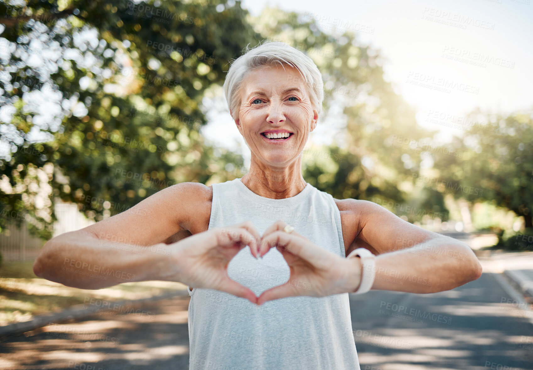 Buy stock photo Fitness, happy and heart hands of old woman in nature after running for health, wellness and workout. Smile, motivation and peace with senior lady and sign for love, faith and training in nature