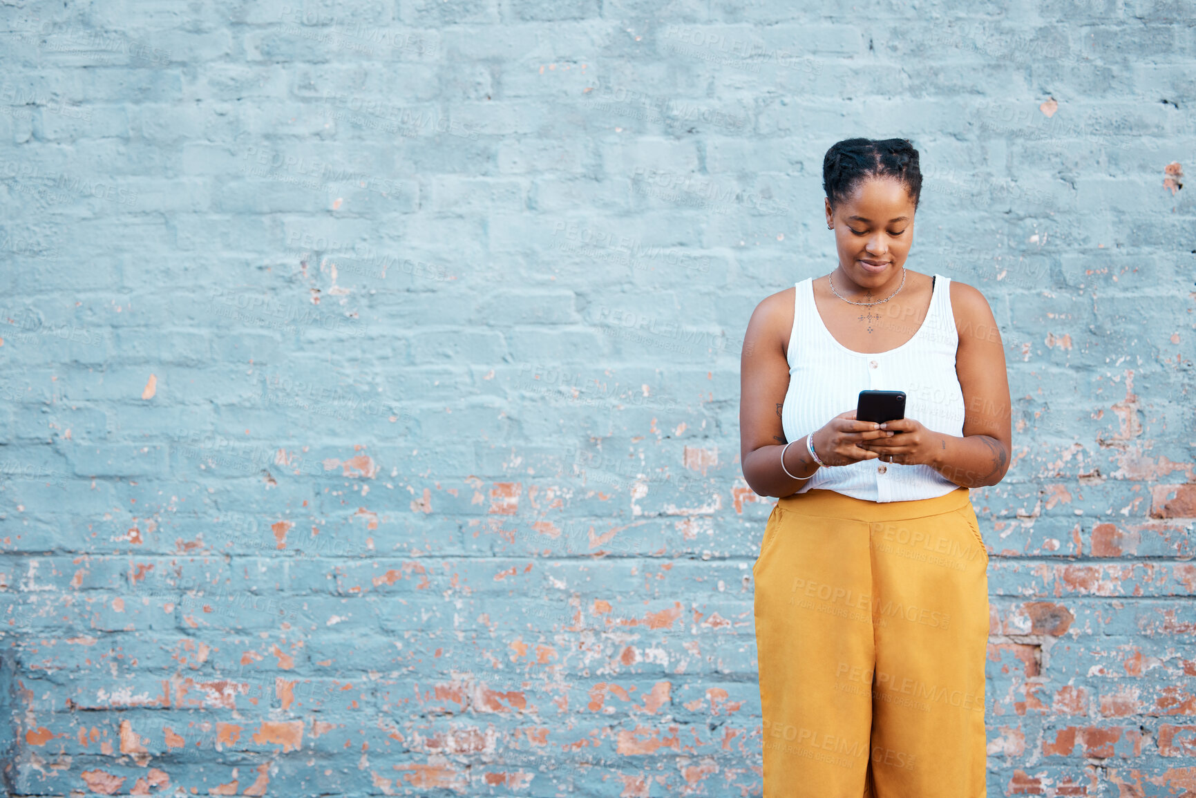 Buy stock photo Black woman, fashion and phone by mock up wall in Nigerian city for marketing, advertising or sales deal promotion mockup. Smile, happy or trend student with mobile technology for social media search