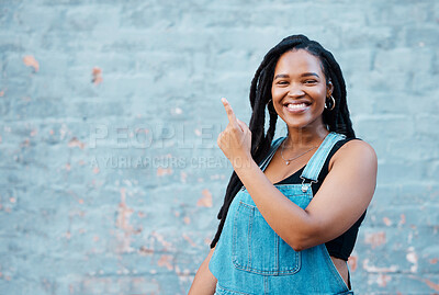 Buy stock photo Black woman, portrait and pointing to mockup background wall space for advertising, marketing news and announcement in urban city outdoors. Happy, smile and young hipster gen z girl promote message