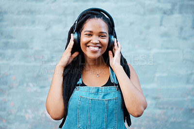 Buy stock photo Gen z black woman, music headphones and portrait on wall background in Nigeria city listening to radio, audio and sound. Happy young african girl student, freedom and streaming urban outdoor podcast