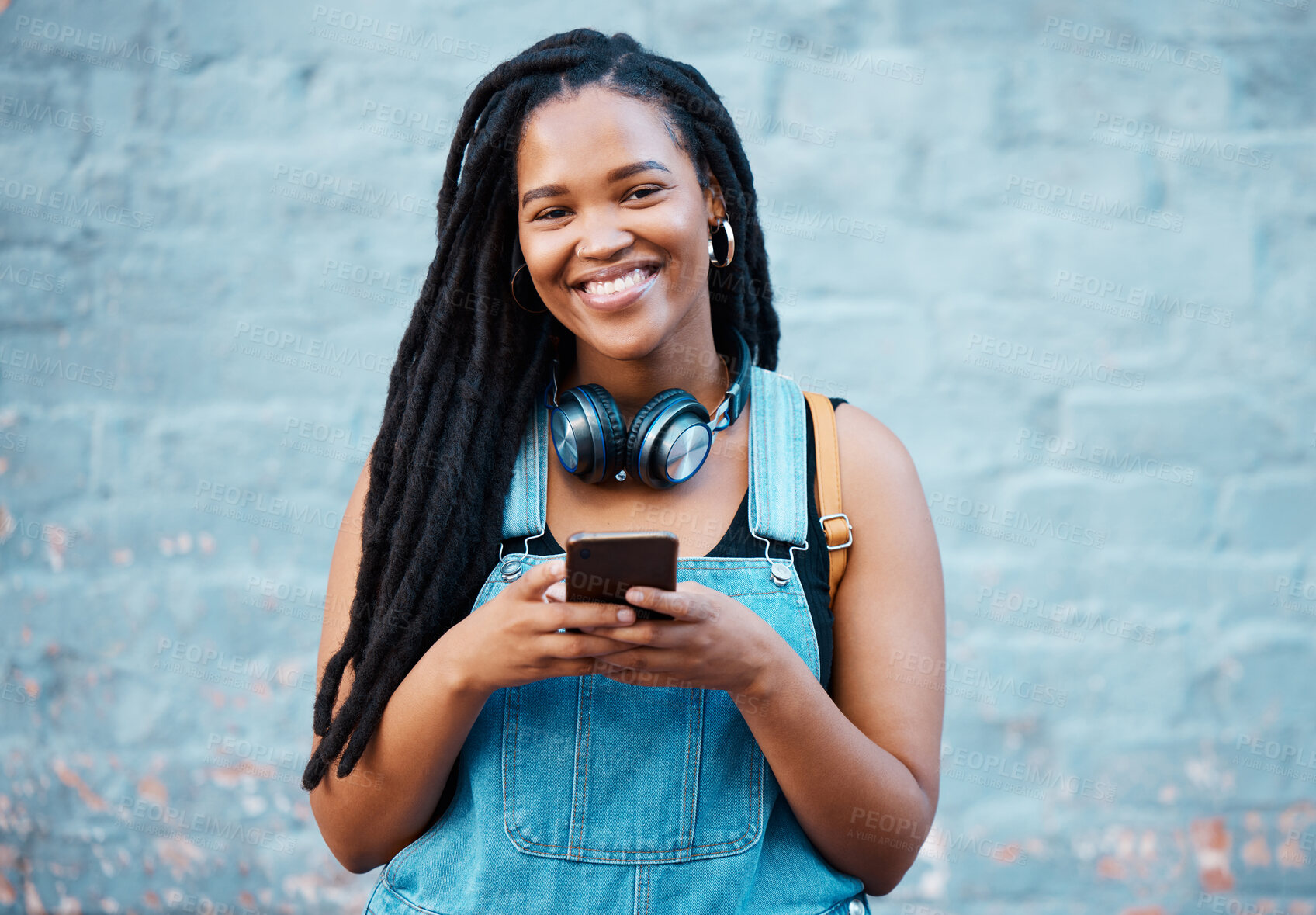 Buy stock photo Black woman, happy and phone in city on travel, walk or adventure in urban street. Girl, smartphone and smile against wall in Atlanta on vacation, holiday or break while in communication online