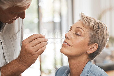 Buy stock photo Covid, healthcare and test with a woman and man doing a nasal swab in the home for pcr testing. Medical, care and insurance with a senior couple in a house during the corona virus pandemic