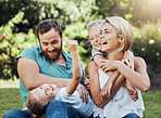 Family, children and love with mother, kids and father playing in the park during summer, laughing and having fun together. Happy, freedom and playful with a girl, boy and parents sitting on grass