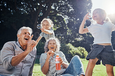 Buy stock photo Grandparents, bubbles and children play in park happy together for fun, joy and outdoor happiness. Retired, smile and excited elderly senior couple, girl grandkids and love playing outside in nature