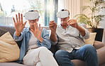 Senior couple and vr technology for metaverse retirement fun and futuristic simulation in home. Married people enjoy 3d virtual reality glasses experience for leisure entertainment on sofa.

