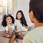 Mother, family and girl throw popcorn on sofa in home living room. Love, relax and child or kid with parents feeding food to person, spending time together and bonding in house having fun playing.