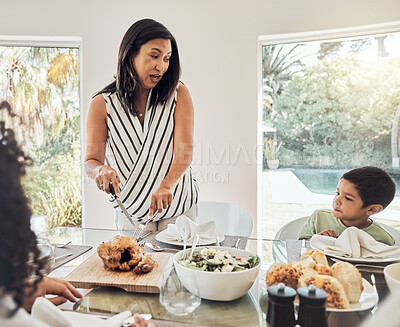 Buy stock photo Grandmother talking to children in dining room, food ready for dinner and share family home recipe in Mexico. Elderly woman cutting chicken on table, eat healthy together and grandma with hungry kids