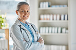 Medical portrait, healthcare doctor and woman with smile for working in medicine at a pharmacy. Happy, mature and expert pharmacist with arms crossed and pride while consulting in a hospital 