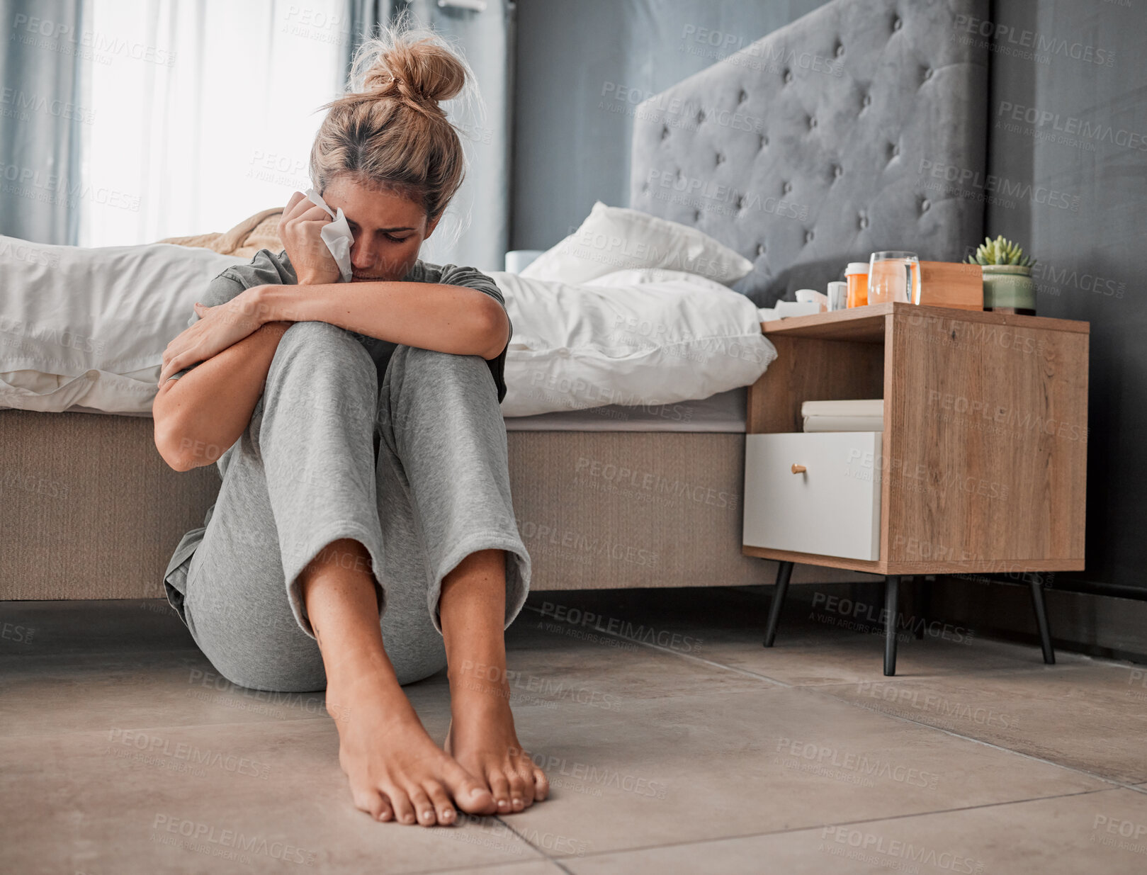Buy stock photo Crying, sad and depressed woman on bedroom floor using wipe for tears struggling with mental health, depression and anxiety after heartbreak or breakup. Upset or sick female cry about problem at home