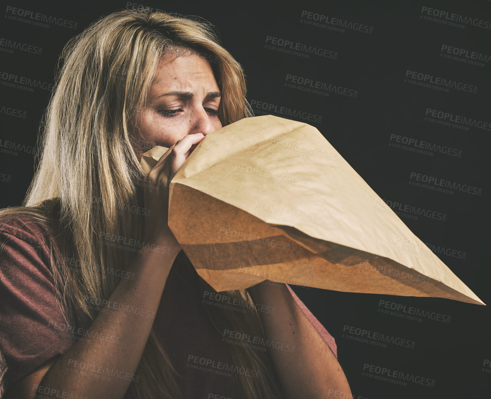 Buy stock photo Anxiety, breathing and scared woman with paper bag, mental health and emergency oxygen air for lungs on black background. Panic attack breathe problem, stress and fear of depression, nausea and sick