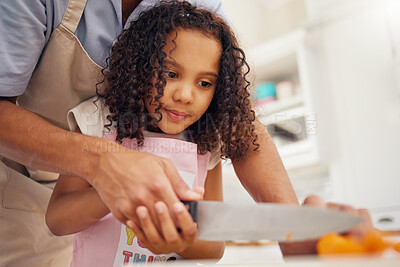 Buy stock photo Father with kid helping her in the kitchen and cooking food together. Dad helps girl chop vegetable or fruit for healthy meal for lunch. Child development, teaching and learning how to cook at home