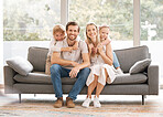 Happy, family smile and relax in living room sofa for holiday break together at home. Portrait of white couple and kids relaxing, smiling and enjoying time in happiness sitting on couch in the lounge