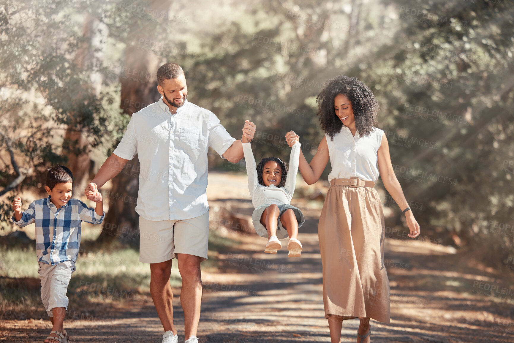 Buy stock photo Family, happy and park summer fun of a father, mother and children swinging on a nature path. Happiness of parents holding hands with kids together with love, smile and support outdoor walking