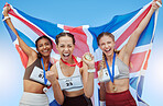 Cheerful diverse group of female olympic athletes holding winner's medals and British flag. Happy and proud champions of United Kingdom. Winning a medal for your country is an amazing achievement