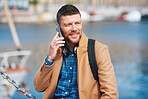 Businessman man using smartphone having phone call talking on mobile phone in waterfront harbour