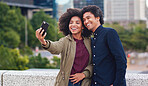 Happy couple taking selfie photos using smartphone in city photographing romantic date together with mobile phone camera