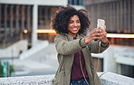 African american woman taking selfie photo using smartphone in city with mobile phone camera
