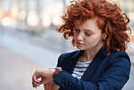 Beautiful business woman using smart watch in city red head female with wearable mobile technology