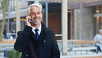 Mature businessman using smartphone talking on mobile phone in city