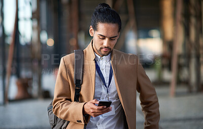 Buy stock photo Young businessman using smartphone texting on mobile phone in city