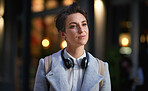 Portrait young business woman in city wearing headphones