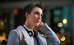 Portrait young business woman in city wearing headphones