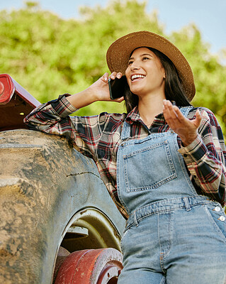 Buy stock photo Agriculture, sustainability and farmer talking on phone while working on a farm with a tractor. Wellness, health and agro woman networking with a mobile while standing on a field in the countryside.