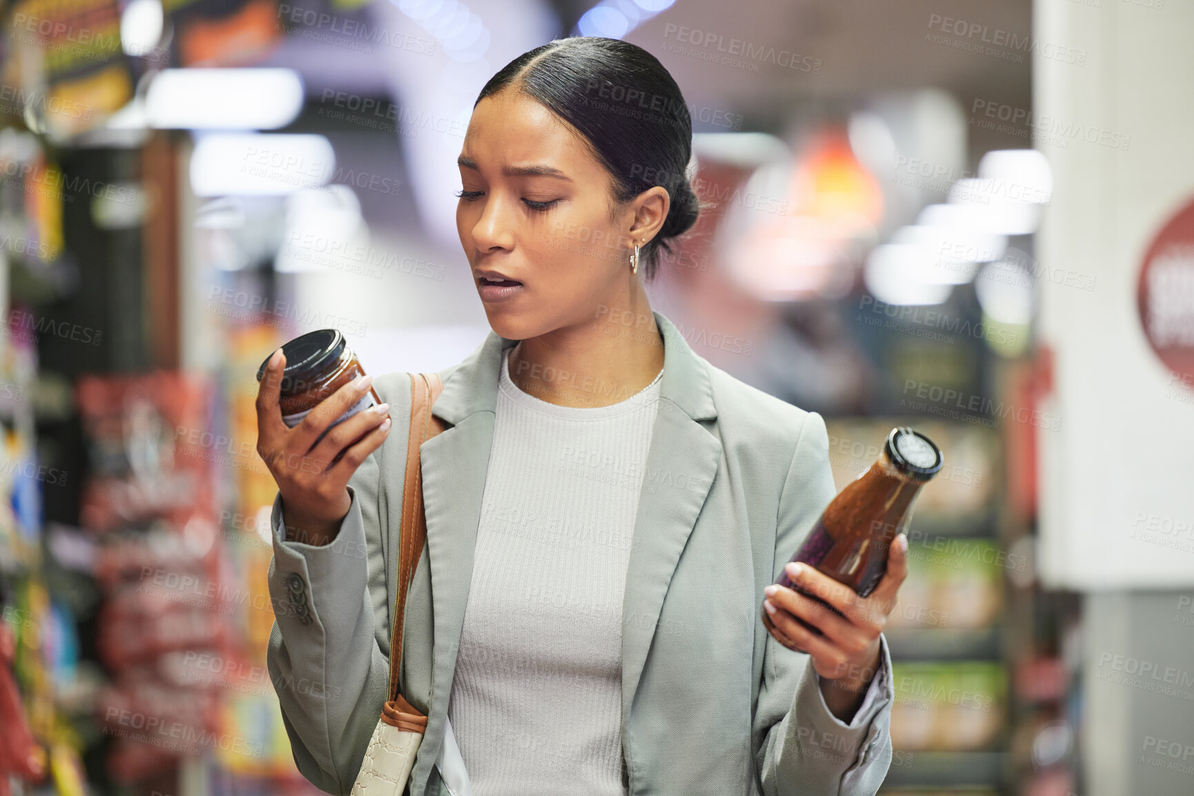 Buy stock photo Shopping, retail and customer in a store or supermarket, reading product labels of choice to decide or compare sauce bottles. Consumerism, spending and shopping for food, groceries and a sale offer