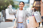 Woman shopping, fashion and retail gift bags for customer buying stylish clothes and spending money on a city spree. Portrait smile, happy and fun lady with cool, trendy and sales presents from store