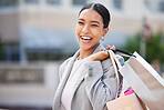 Shopping, retail and sale with a young woman in the city to spend money and shop at a store or mall. Portrait of a happy, carefree and urban customer with a smile holding bags out on the town