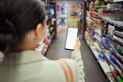 Buy stock photo Woman shopping with phone screen at shop, reading grocery list on smartphone and looking for food items at a store. Back of a person buying meal products, household items on the weekend