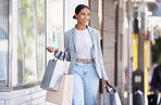 Happy, smile and fashion woman shopping for new clothes in style and buying modern outfits with her money. Fun, lifestyle and young shopper walking outside of a retail store smiling with happiness