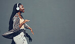 Music, university and college dance student dancing and listening to podcast or radio on headphone walking past campus. Copy space banner for education mock up content on grey wall background.