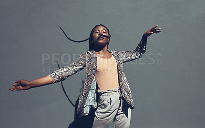 Buy stock photo Fashion, style and trendy black woman against a gray background wall in a city, town and downtown. Street beauty model with funky, cool and hipster hair in edgy motion or movement expression outdoors