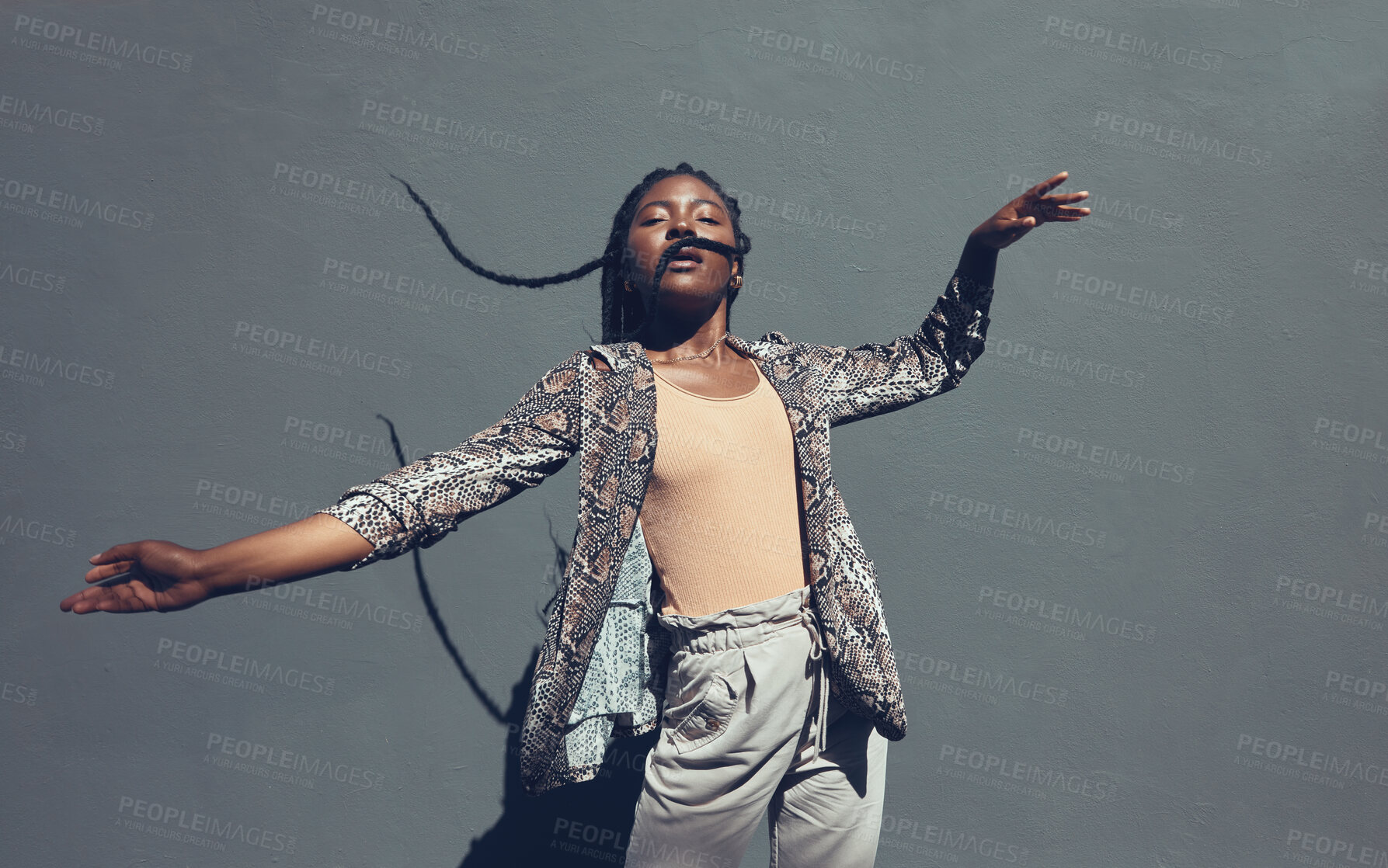 Buy stock photo Fashion, style and trendy black woman against a gray background wall in a city, town and downtown. Street beauty model with funky, cool and hipster hair in edgy motion or movement expression outdoors