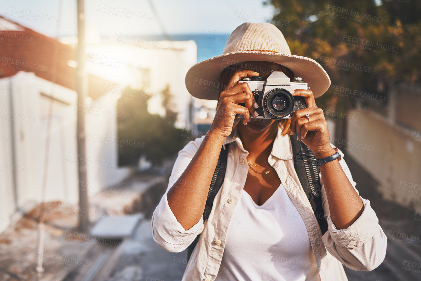 Buy stock photo Photographer, travel or tourist taking pictures or photos outdoors in a new town. Traveler using a camera while on a trip at a vacation or holiday location on a sunny day doing a photoshoot