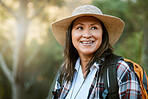 Hiking, adventure and exploring with a mature female hiker enjoying a walk or hike in the forest or woods outside. Senior woman walking on a journey of discovery in nature in the great outdoors