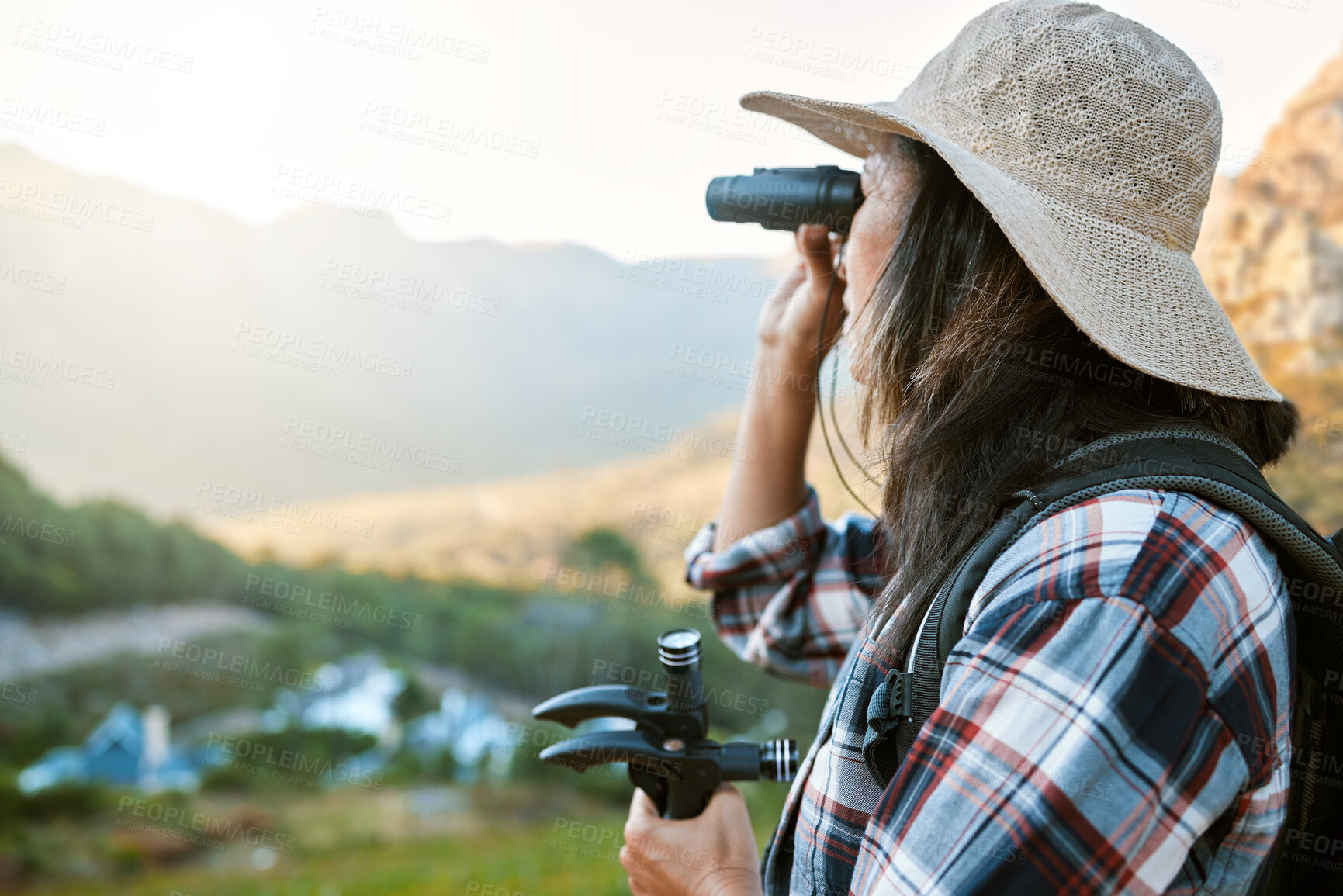 Buy stock photo Hiking, exploration and mountain adventure with binoculars, trekking pole and walking aid in a remote landscape with view. Mature woman, hiker and tourist watching birdlife or wildlife in eco nature